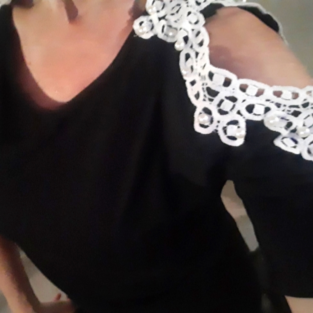 Custom black cold shoulder shirt with white pearl applique in size medium.